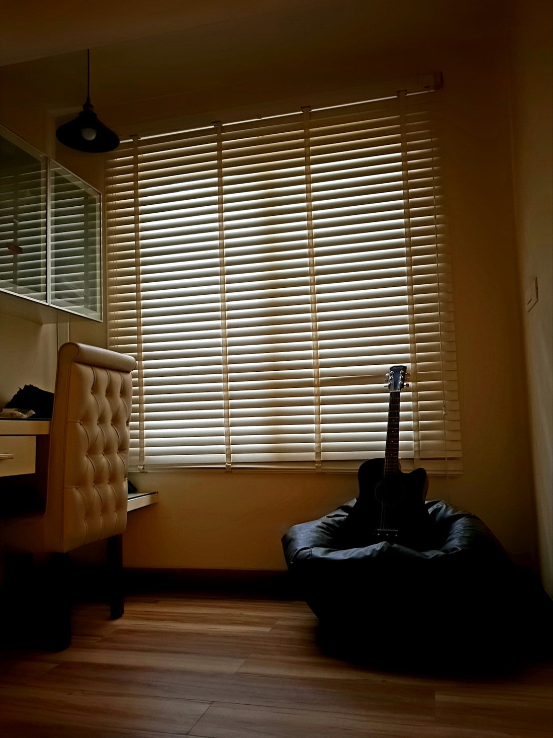 black cat on black cat tree beside white window blinds
