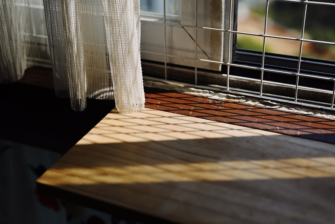 a window sill with a curtain and a window sill in the background