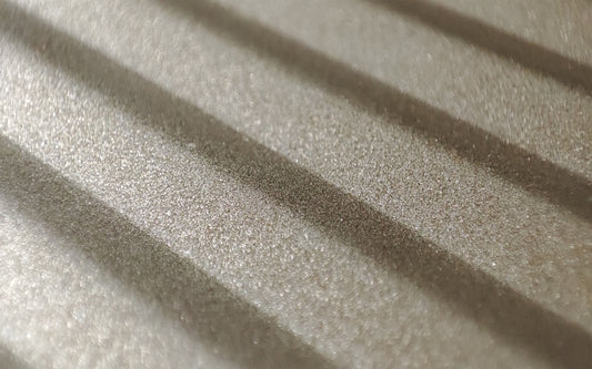 the shadow of the blinds on a bed