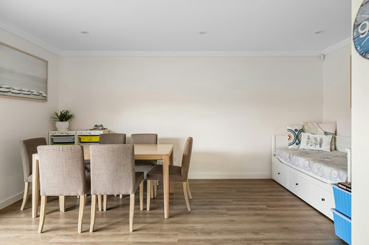A room with a table and chairs and a clock on the wall
