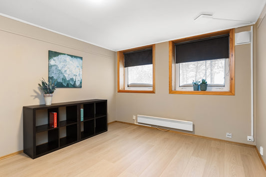 A living room with hard wood floors and windows